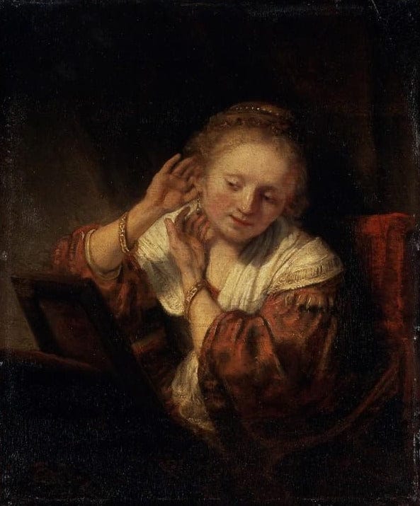 Junge Frau, die Ohrringe anprobiert – Rembrandt van Rijn Rembrandt van Rijn 70x85